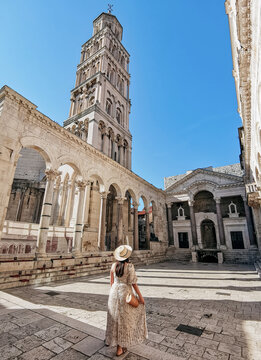 Woman in stylish summer dress standing in Peristyle of Diocletian's palace in Split, Croatia.