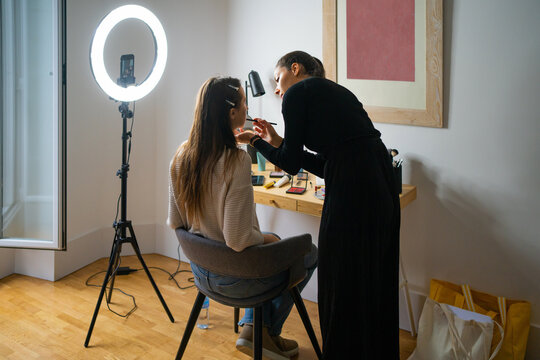 Women Streaming With A Phone While Putting On Makeup. 