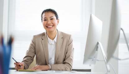 Asian business woman smiling at camera in an office