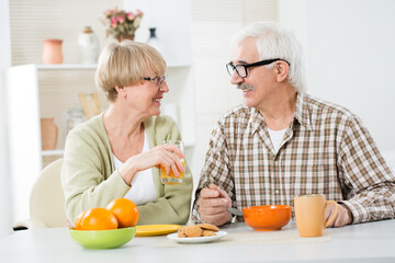 Elderly couple having breakfast together at home
