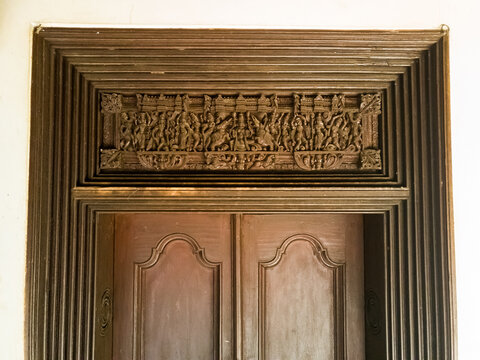 An ornately carved wooden door to an old heritage house in a village in Chettinad.