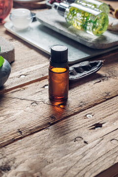 Aromatic oils with herbs in transparent bottles on wooden background