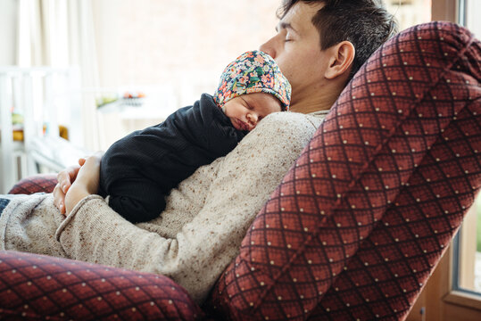 Father and new born daughter having a nap 