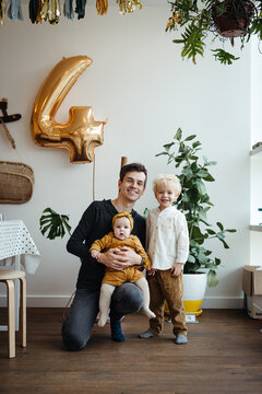 Happy father with his two children on the 4th birthday party of his son