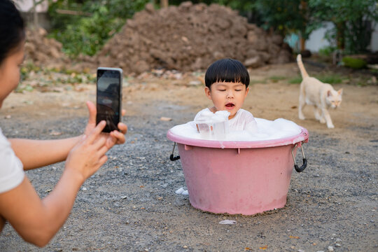 Asian boy take a bath in plastic basin