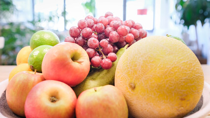 A bowl of fruit sits on a table in an apartment.
