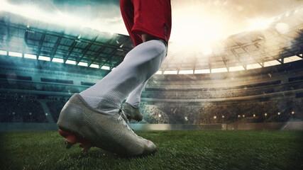 Cropped male soccer, football player in action, motion with ball at the stadium during sport match...