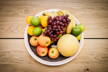 A bowl of fruit sits on a table in an apartment.
