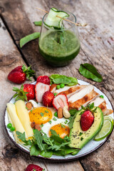 Low carb high fat breakfast, Grilled chicken fillet and avocado, fried eggs with strawberry, cheese and nuts. Detox smoothie, fresh green, Ketogenic diet. Healthy food concept, top view