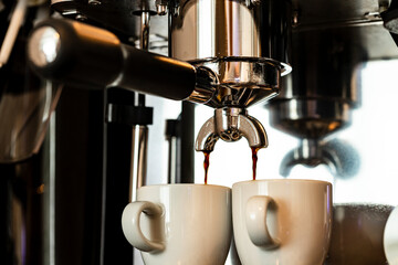 Close up image of professional espresso machine pouring in two cups