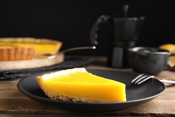 Slice of delicious homemade lemon pie on wooden table