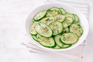 Fresh cucumber salad in bowl on white background
