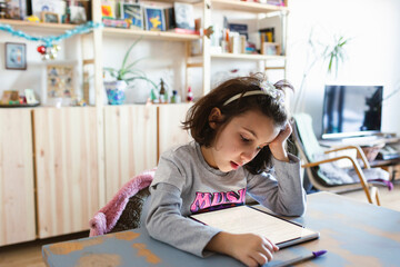 Kid doing homework using electronic device