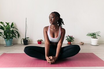 Pensive black woman on her yoga mat