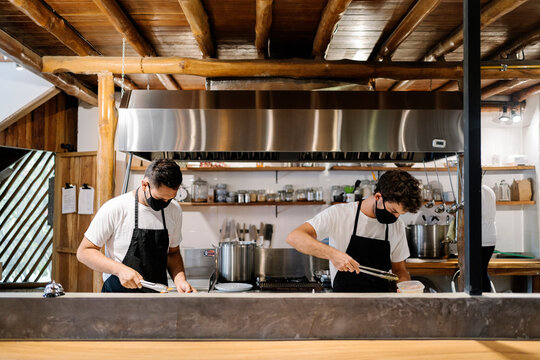 Chefs with Face Mask Working in Kitchen