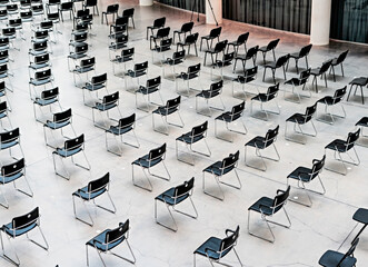 Many black chairs standing indoors at the same distance before the event, pattern, abstract background