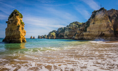 Fototapeta na wymiar Praia da Dona Ana Beach, sandy beach with clear blue water between cliffs on a sunny day, no people, Lagos, Algarve, Portugal