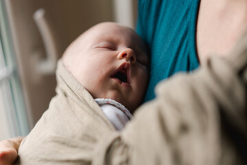 mother wearing her baby in a sling 