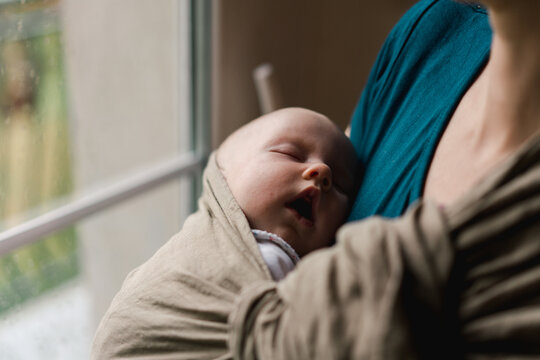 mother wearing her baby in a sling 