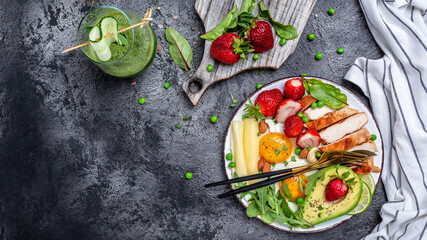 Ketogenic low carbs diet concept, Fried egg, avocado, strawberry, grilled chicken fillet, cheese, nuts and arugula. Detox smoothie, fresh green, banner, menu recipe place for text, top view