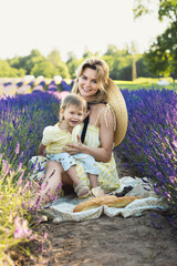 Fototapeta premium Beautiful woman and her cute little son in the lavender field