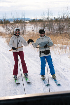 Young couple riding ski hooked to the car
