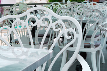 Summer open air mediterranean cafe, white and black chair on terrase or balcony, lazy afternoon