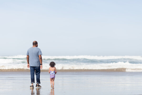 Father and daughter walk in ocean