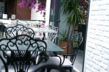 Summer open air mediterranean cafe, white and black chair on terrase or balcony, lazy afternoon