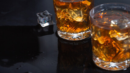 whiskey with ice in glasses close-up, strong alcohol