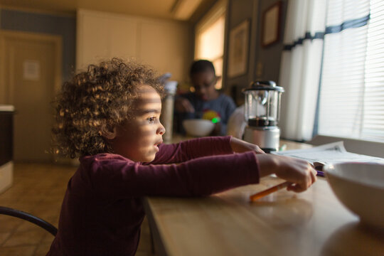 Girl in sunlight at breakfast table