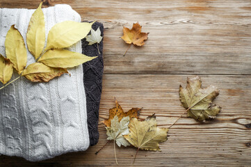 Autumn background with knitted sweaters and aautumn leaves