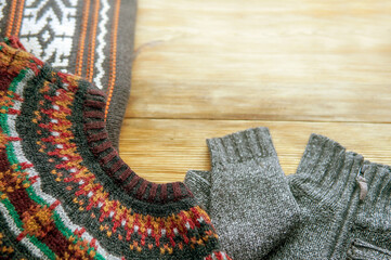 Autumn background with knitted sweaters over wooden background