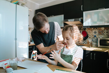 Young father teaches drawing daughter. 