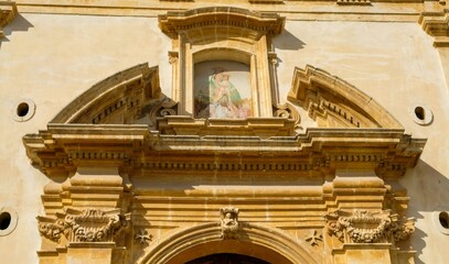 Fototapeta na wymiar Noto, Sicily. Entrance details of Chiesa di San Giovanni Battista alle Anime Sante, built in the first half of the 18th century.