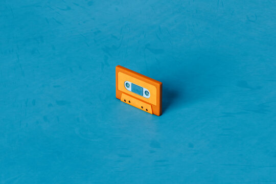Orange musicassette on blue background