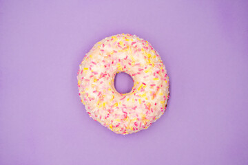 Fototapeta na wymiar Donut de virutas de colores sobre fondo morado