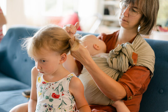 mother fixing little girl's hair