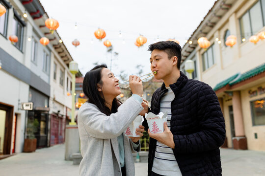 Young Asian Couple Feed Each Other While Eating Takeout