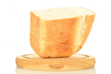 One half of a loaf of flavored wheat bread on a round wooden tray, close-up, isolated on white.