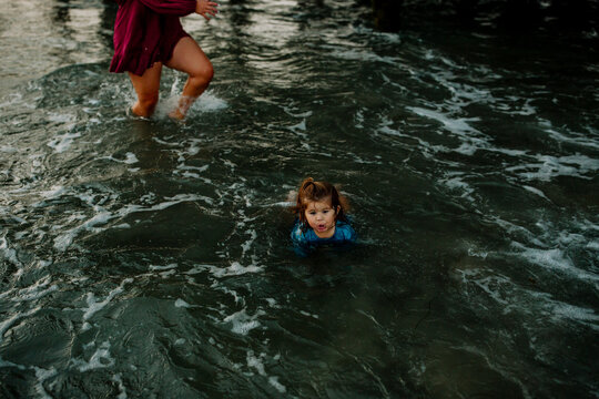 Young girl swimming in shallow ocean water