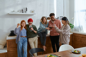 Friends Toast red wine at a Celebration at home in the kitchen