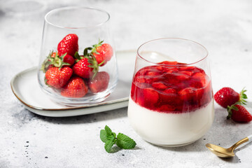 Vegan coconut panna cotta with strawberries in glass on gray background. Vegan food concept. close-up