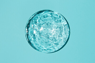 Close-up transparent cosmetic gel in glass isolated on blue background