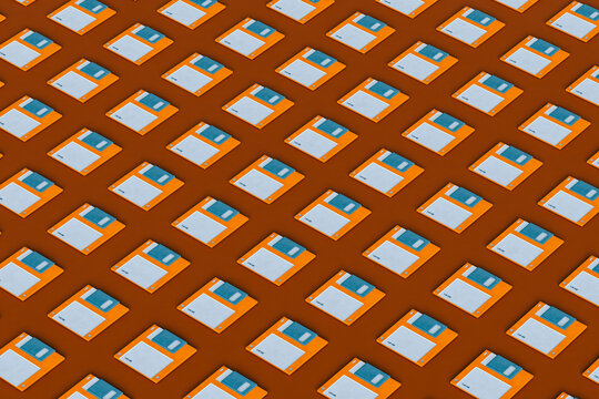 Blue and orange Floppy disks layed  on brown background 