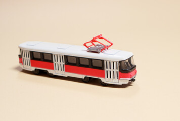 Children's toy red white tram on a beige background copy space for text. Toys for a toy store, cars...
