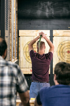 Rear View Of Man Two Hand Throwing An Axe