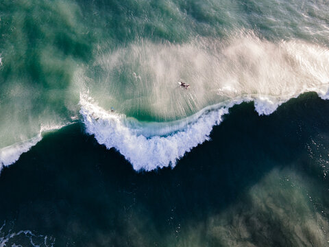 Surfers emerging from a from duck diving a large wave