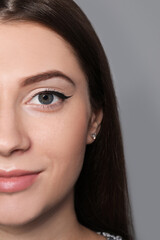 Fototapeta premium Beautiful woman with black eyeliner on grey background, closeup