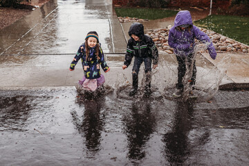 Siblings splashing in rain